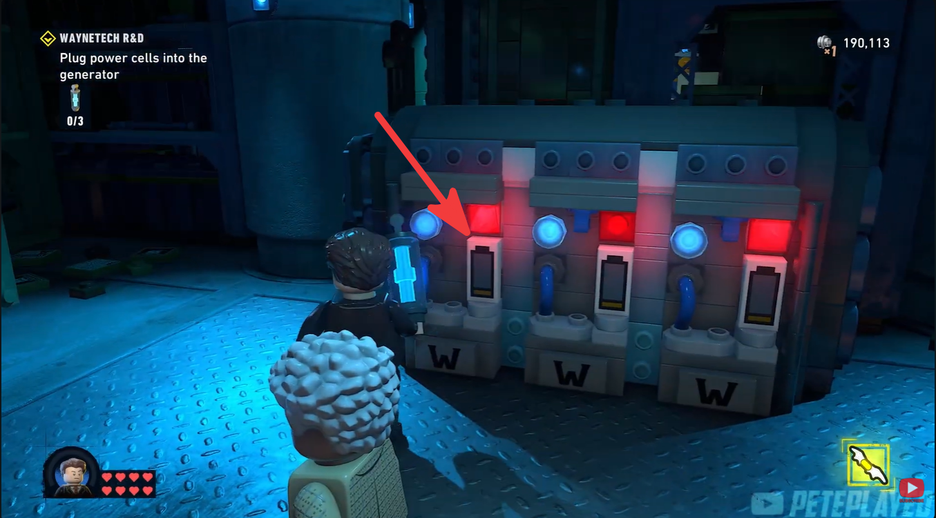 Batman inserting the first Power Cell into the WayneTech generator socket in LEGO Batman: Legacy of the Dark Knight