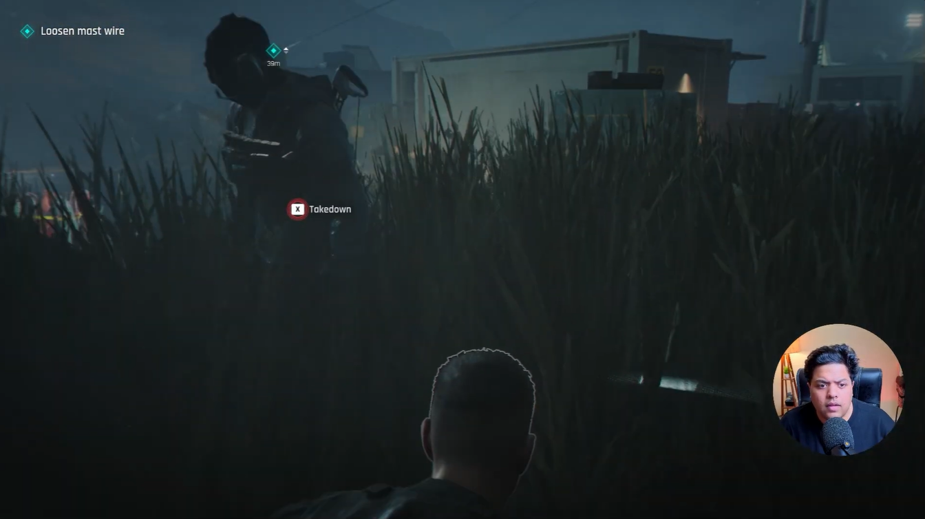 Stealth takedown prompt appearing on a guard hidden in tall grass near the camp during the mast wire sabotage mission in 007 First Light.