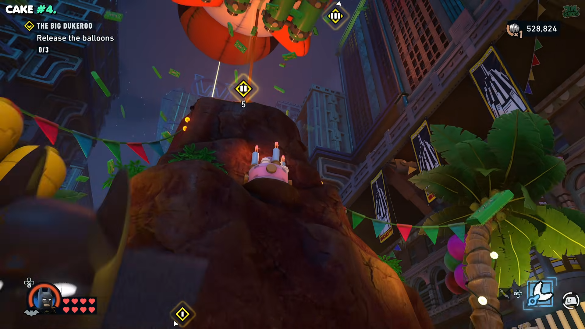 Batman turning around from the second balloon to the mountain with a cake on top in the Big Dukeroo in Lego Batman: Legacy of the Dark Knight