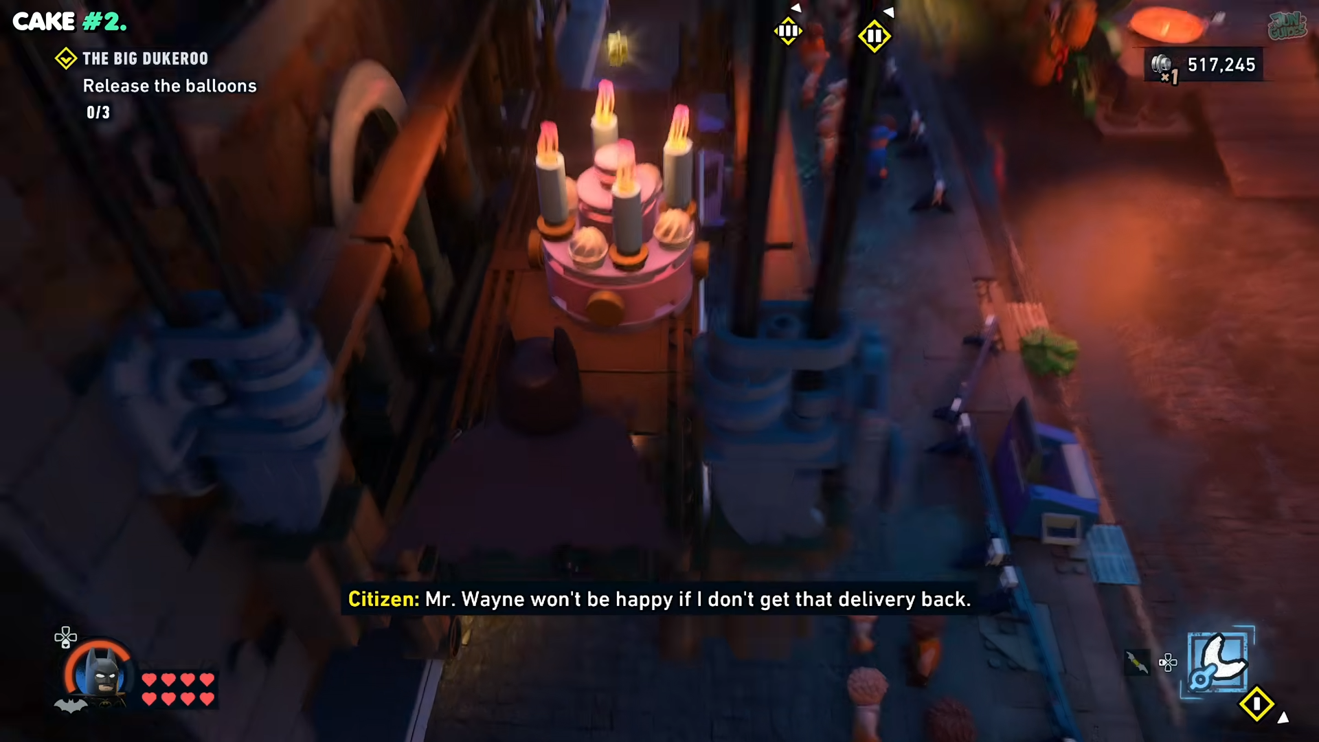 Batman looking at a cake on the side window cleaning platform in Lego Batman: Legacy of the Dark Knight