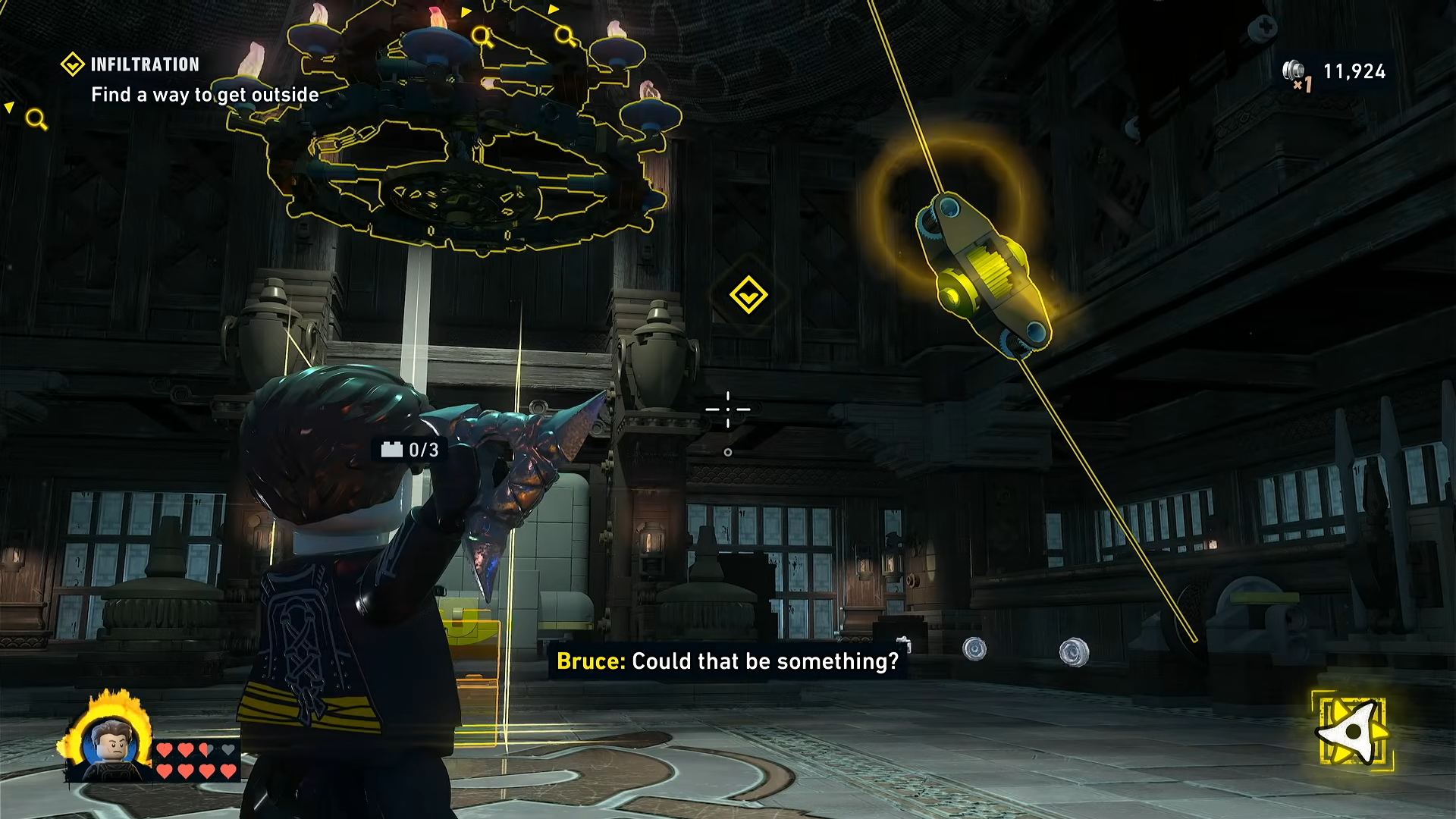View of the Infiltration mission throne room showing the hanging chandelier and two decorated LEGO structures in the center that must be broken in LEGO Batman: Legacy of the Dark Knight