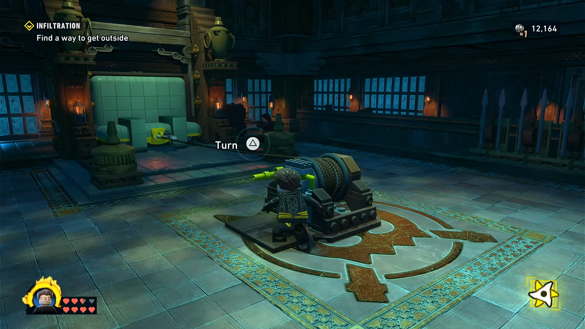 Batman turning the winch crank to drag the bed out of its small alcove onto the ledge in LEGO Batman: Legacy of the Dark Knight