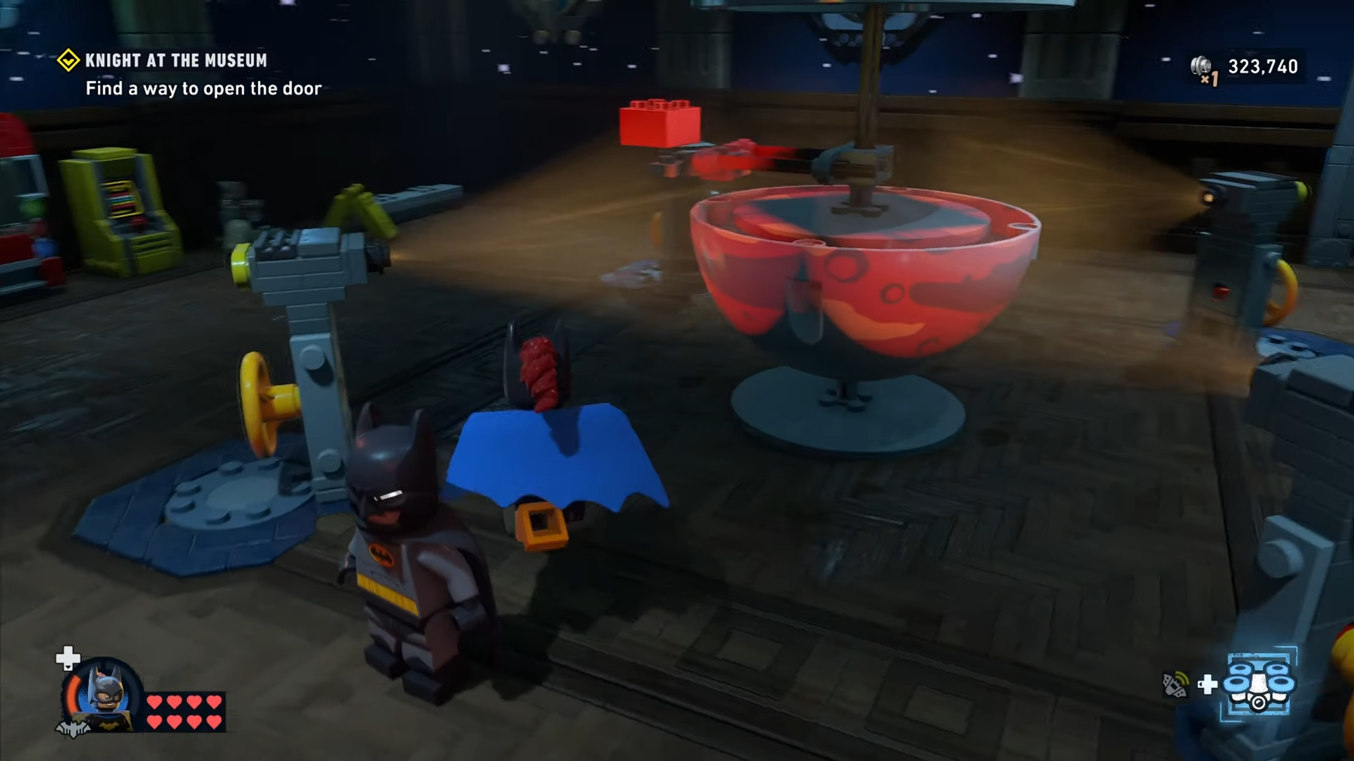 Red brick jumps out of the central globe in Knight at the Museum mission in Lego Batman: Legacy of the Dark Knight.