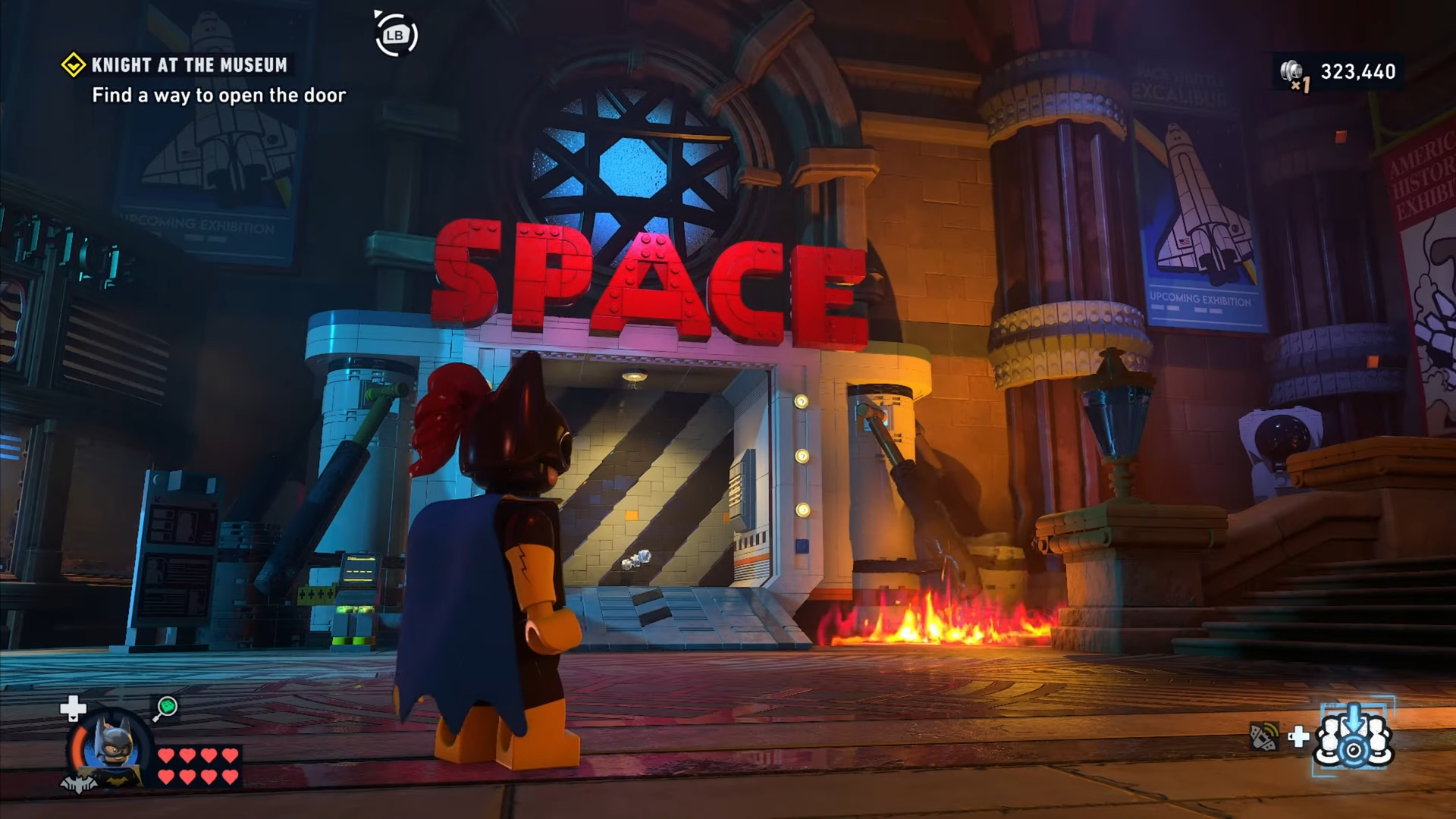 Character standing in front of a door labelled SPACE in Knight at the Museum mission in Lego Batman: Legacy of the Dark Knight.