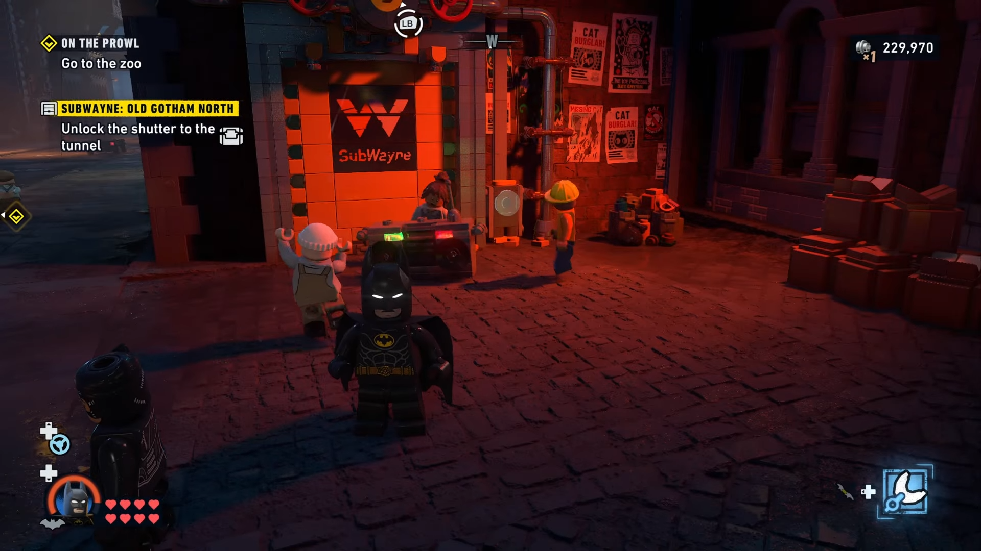Batman standing in front of the Old Gotham North Subwayne tunnel with civilians partying before it in Lego Batman: Legacy Of The Dark Knight: