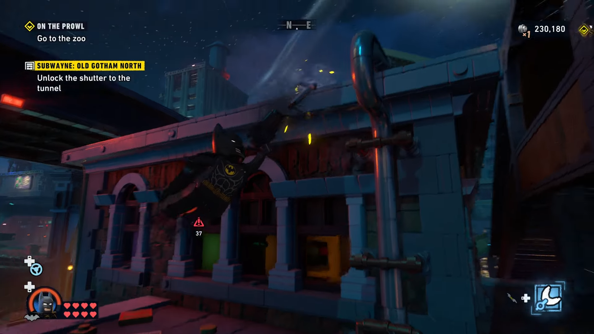 Batman grappling his way to the top of the building at Old Gotham North in Lego Batman: Legacy Of The Dark Knight: