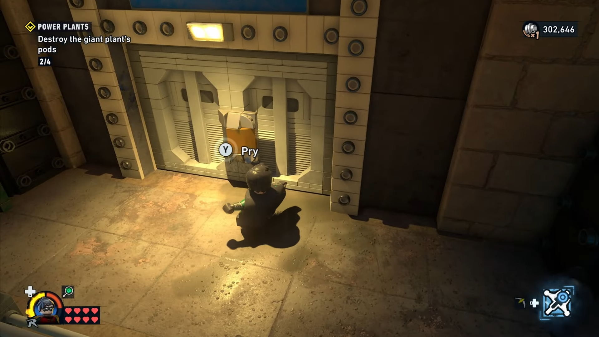 Robin pries open the lock to a gate in Power Plants mission in Lego Batman: Legacy of the Dark Knight.