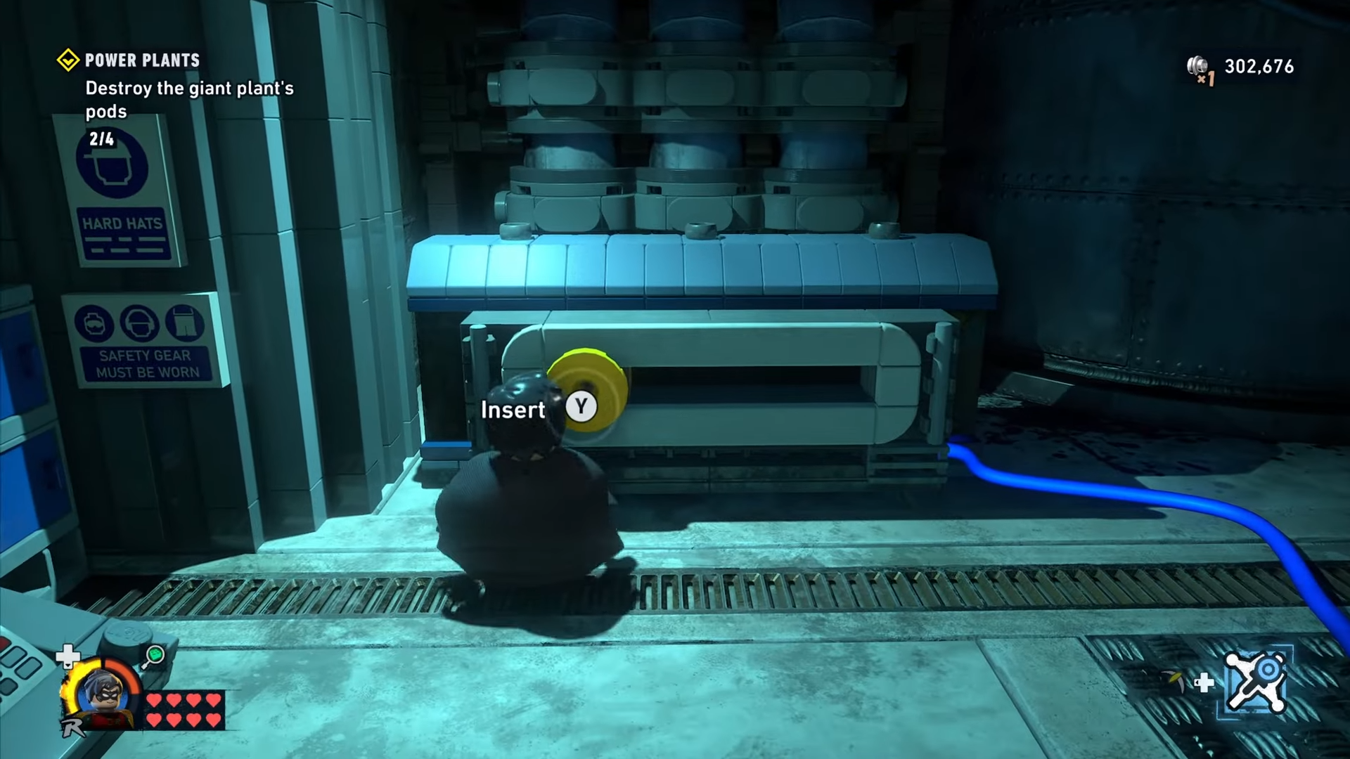 Robin stands before a powered mechanism in Power Plants mission in Lego Batman: Legacy of the Dark Knight.