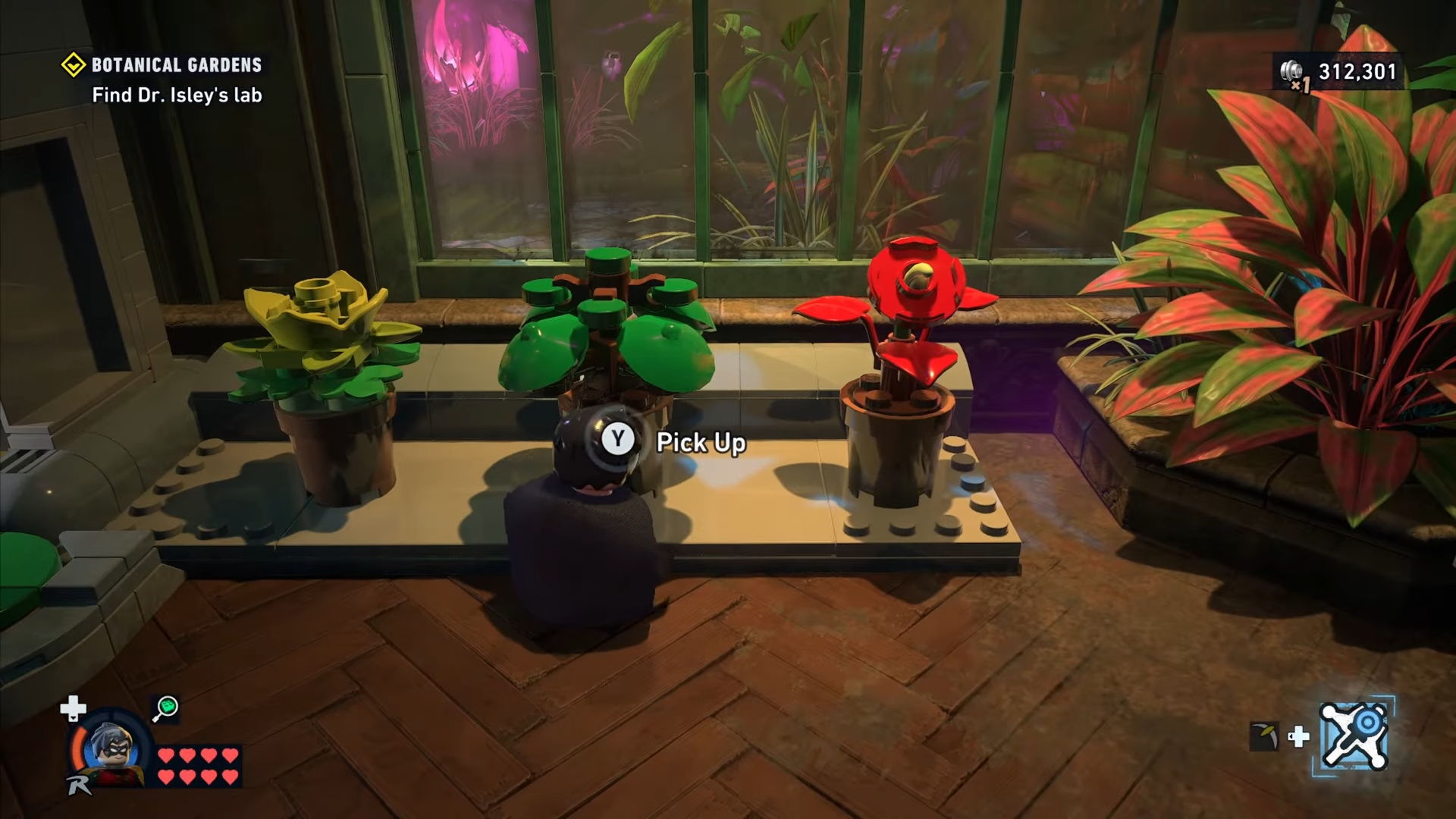Robin picking up a green plant in Botanical Gardens in Lego Batman: Legacy of the Dark Knight.