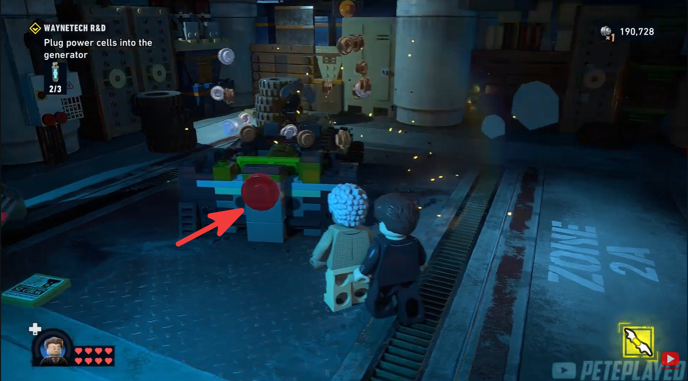 Batman presses the red activation button in LEGO Batman: Legacy of the Dark Knight