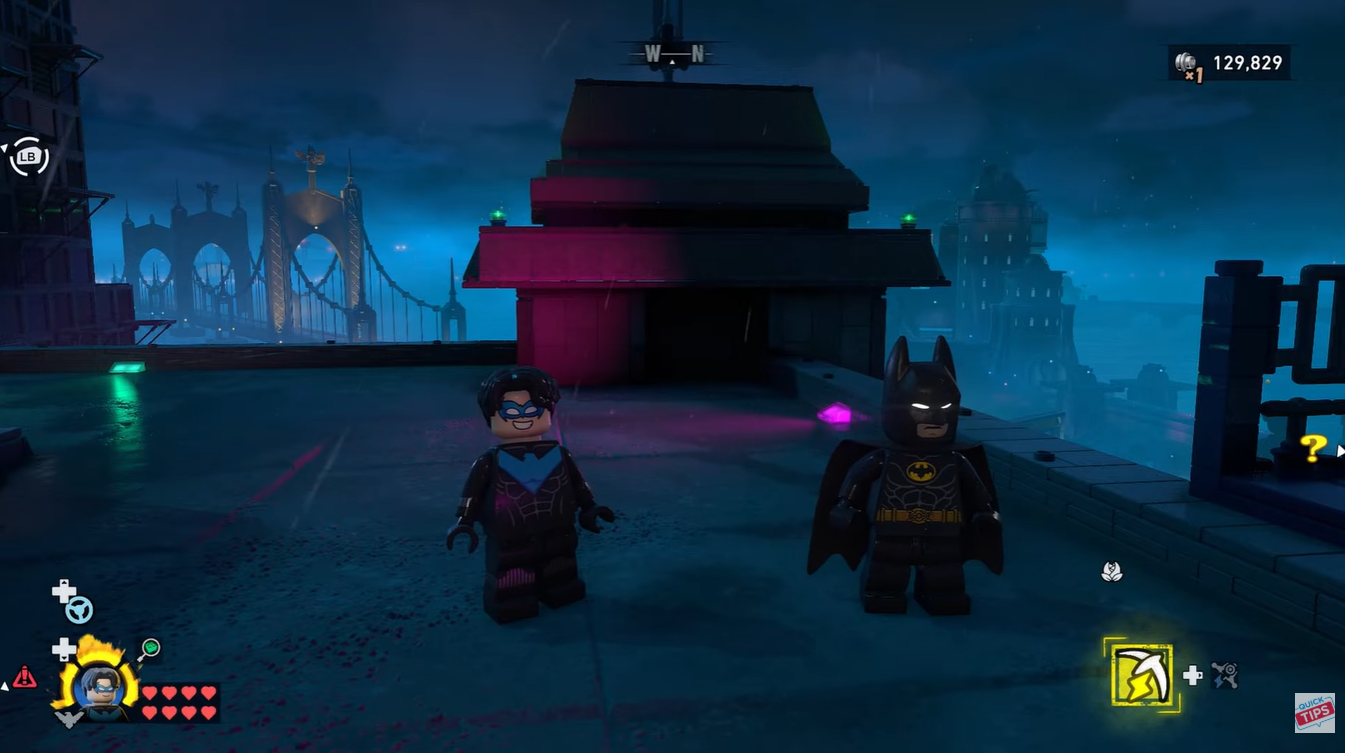 Batman and Nightwing standing on a roff in Gotham City in LEGO Batman: Legacy of the Dark Knight 