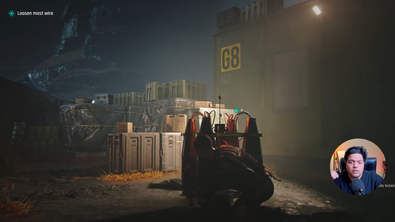 Bond crouching behind cover near the G8 container area while moving toward the loosen mast wire objective in 007 First Light.